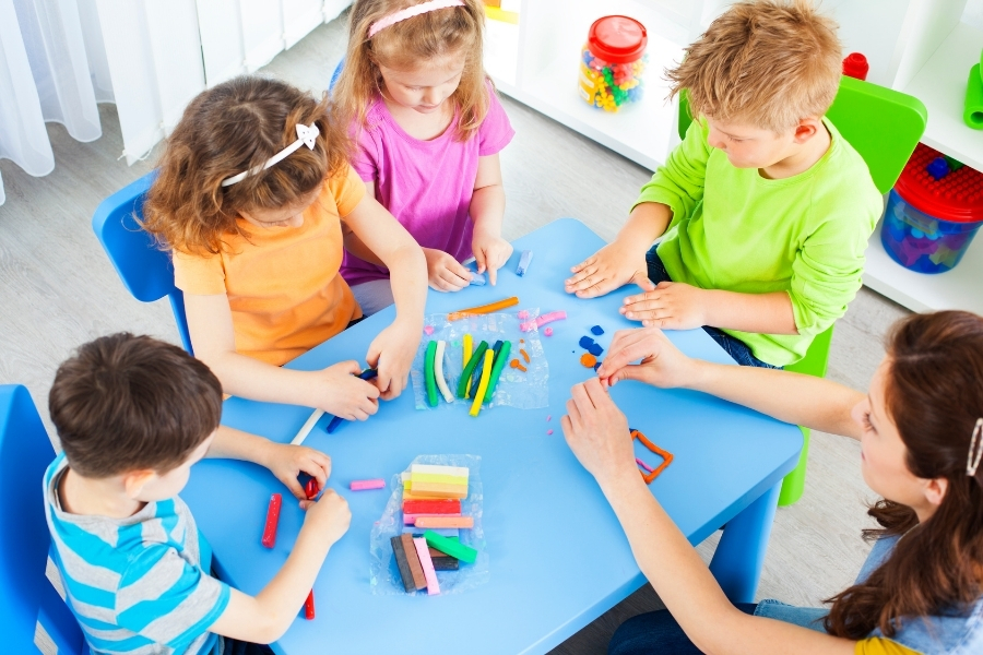 Preschool children engaging in open-ended creative play with colorful playdough during early childhood education activities.